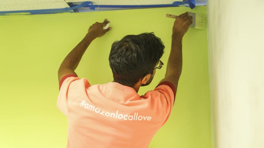 AN AMAZON VOLUNTEER PAINTS one of the walls at Homestretch during the e-commerce and cloud computing company’s Local Love day at the Falls Church-based nonprofit. The Local Love program renovated the employment center, remodeled the multipurpose room and created a new health and wellness center at Homestretch. (Courtesy Photo)