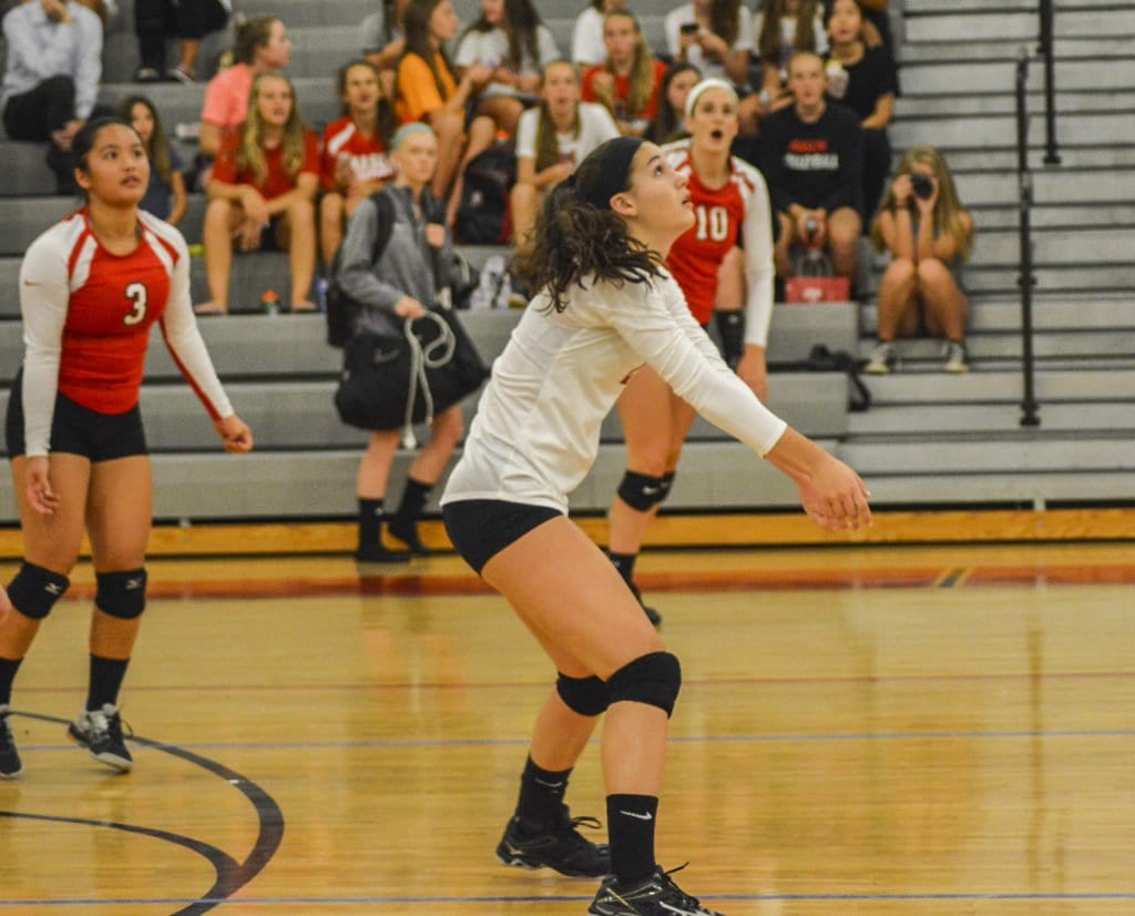 SENIOR SHAUN RODOCK GETS READY to return a hit during an early season victory for the Mustangs while her fellow seniors, Dre Dilao (left) and Kate Karstens (right) watch. Rodock stood out on the defensive side in the Mustangs defeat of Clarke County. (Photo: Carol Sly)