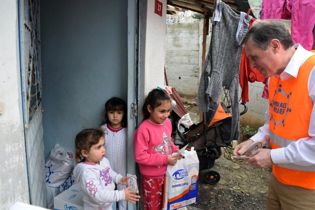 FALLS CHURCH MAYOR David Tarter (right) is shown in Istanbul, Turkey presenting coats and blankets to child refugees earlier this month. Tarter was part of a delegation of the Northern Virginia Regional Commission, whose participating jurisdictions collected the vital aid to the countless Syrian refugees who have fled to Turkey. (See News Briefs, page 9). (Photo: News-Press)