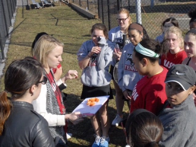Members of the girls varsity tennis team gather around Ware for a few announcements before a match. Last season, the team made it all the way to states, before getting eliminated in the second round. (Photo: Courtesy of Anna Connole)