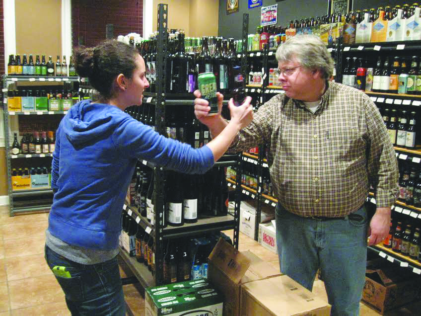 erika amador (left) and John Kay of Red, White & Bleu duke it out over their favorite beers in the store’s indoor “beer garden.” Red, White & Bleu has “Clown Shoes” from Ipswich, Mass. for those looking to represent the New England Patriots with their adult beverage selection this Sunday. (Photo: Patricia Leslie/News-Press)