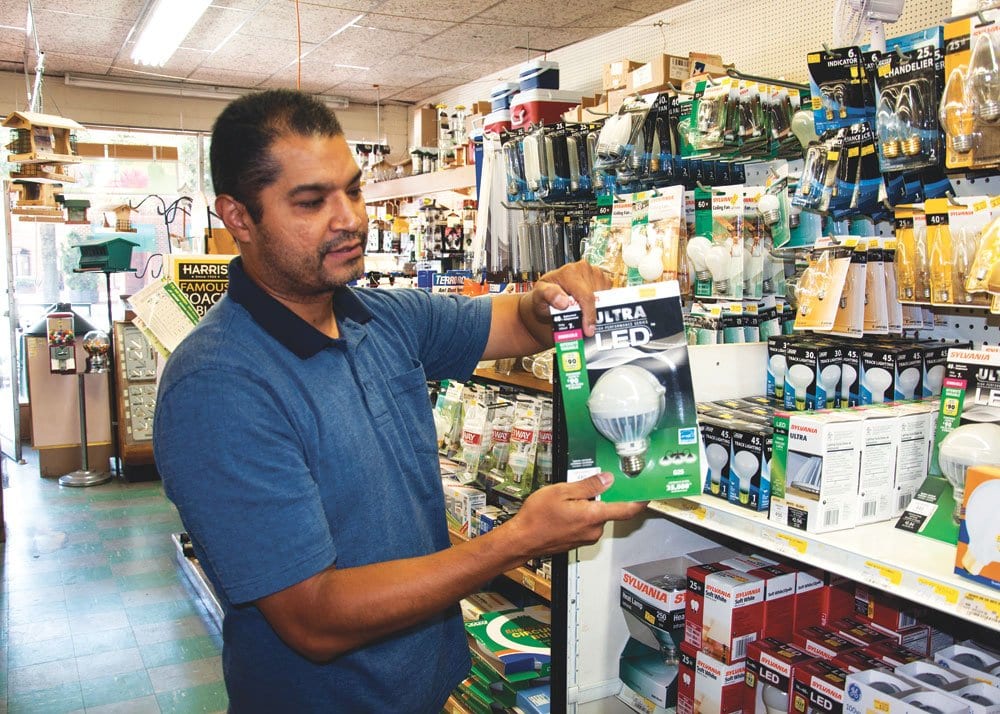 A BROWN’S HARDWARE EMPLOYEE shows off an environmentally-friendly LED lightbulb at the Falls Church store. (Photo: News-Press)