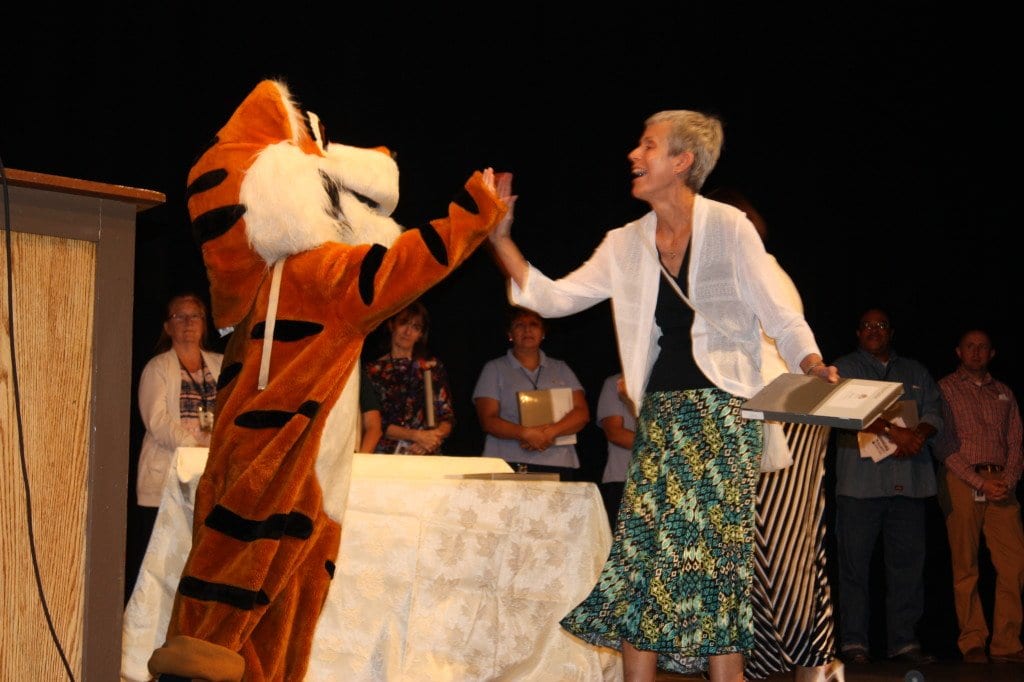 Thomas Jefferson Librarian Helen Heil shares a high-five with a mascot in today's convocation. (Photo: News-Press)
