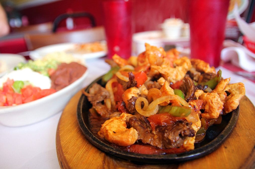 The combo fajitas mix steak, chicken and shrimp on a sizzling iron plate.