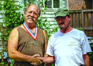 Bob Simpson (right) congratulates Jim Allen, who is donning his first place medal, after Allen won the 2013 Lizzie Borden ax throwing competition. (Photo: Courtesy Bob Simpson)
