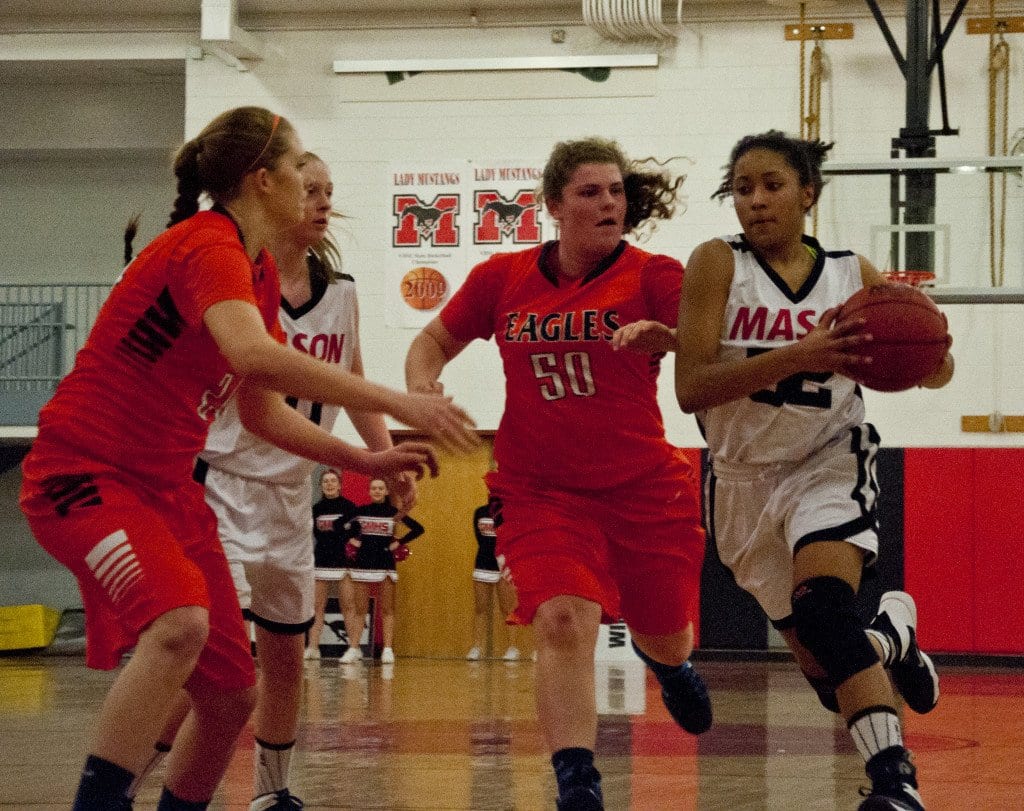 Mason Junior forward Katie Goodwin drives past junior forward Allison Hicks and gets ready to take on junior forward Sydney Chrane. Goodwin scored eight points in the win against the Eagles. (Photo: Drew Costley)