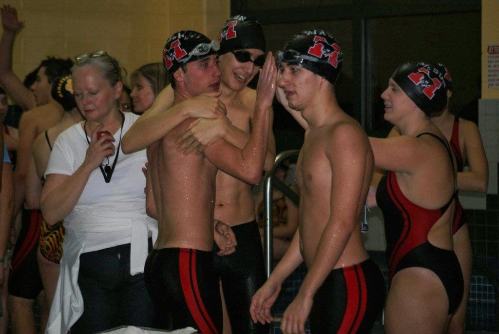 Mason swimmer Nabil Osborn hugs John Marshall, who gets a high five from Sara Mills while Daniel Nette cheers Nik Hokaj finishing up the 200-yard freestyle relay. The team placed second at 1:52.87. (Photo: Courtesy Carol Sly)
