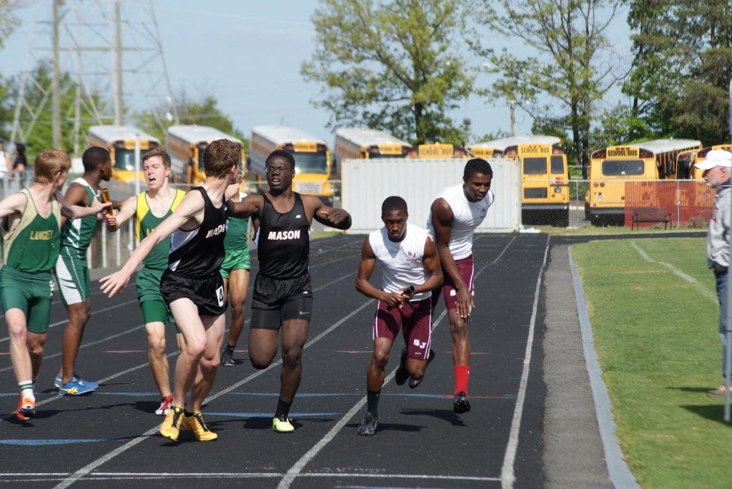Michael Addo-Ashong passes the baton to Truman Custer for the final leg of the 4x400 relay that qualified the team for the state meet with a time of 3:38.16. (Photo: Carol Sly)