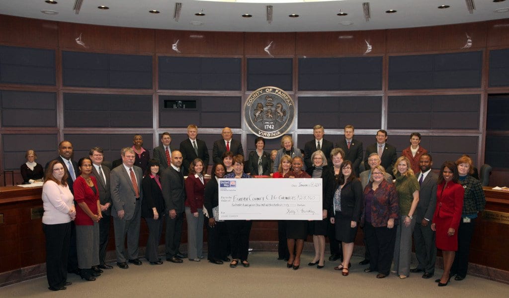 United Way’s Kelly Brinkley awards Community Impact Grants checks at the first Fairfax County Board of Supervisors meeting of the year. Brinkley (with check, right) is pictured with the Board of Supervisors (top row, center) and representatives from the Fairfax/Falls Church grantees. (Courtesy Photo)